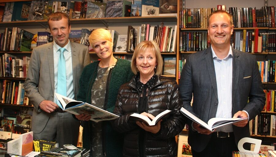 4 pesonar med bøker i hende. Foto.