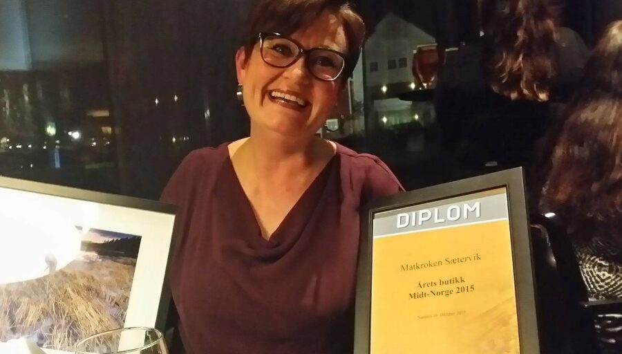 Person med diplom og blomst. Foto.