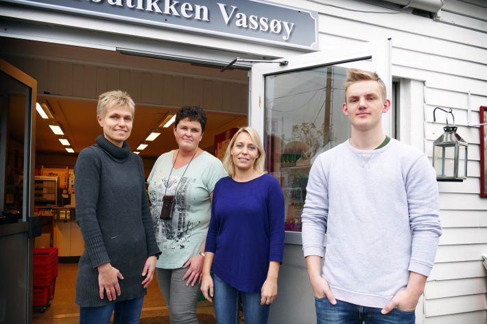 4 personer utenfor butikk. Foto.