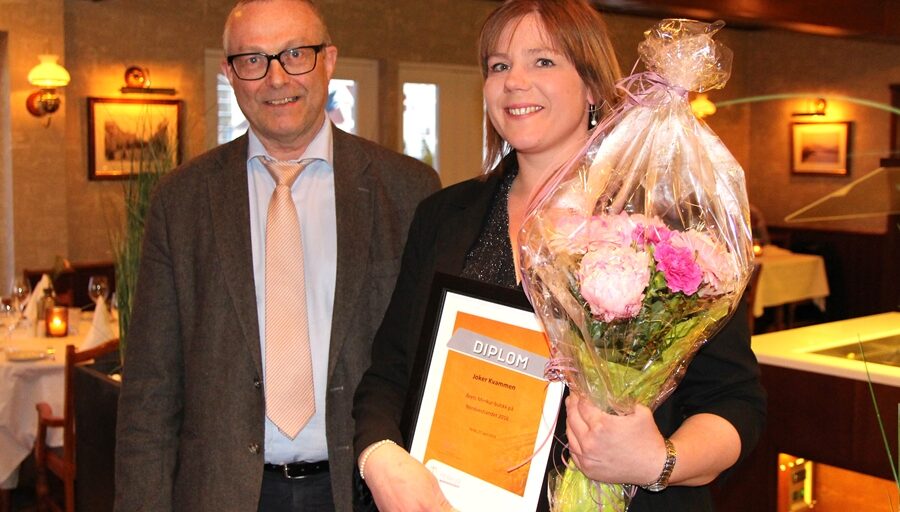 2 personar med diplom og blomst. Foto.
