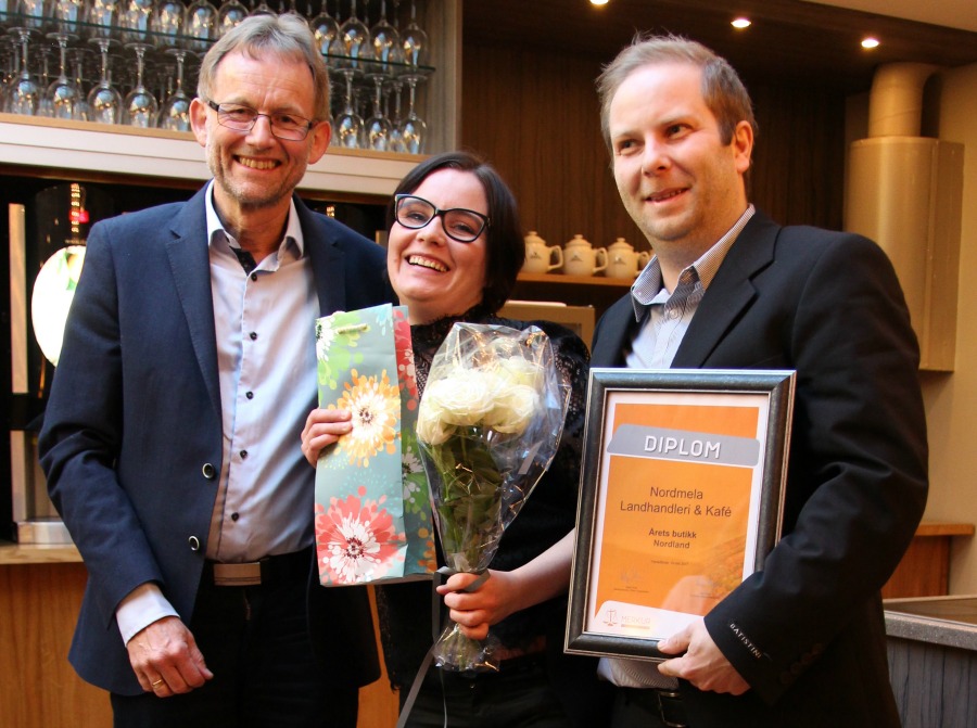 3 personar med blomst og diplom.