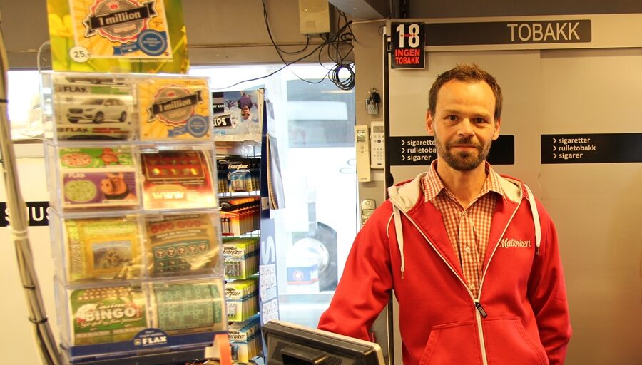 Person i kassen i butikk. Foto.