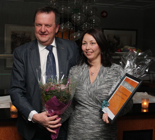 To personar med blomst og diplom. Foto.