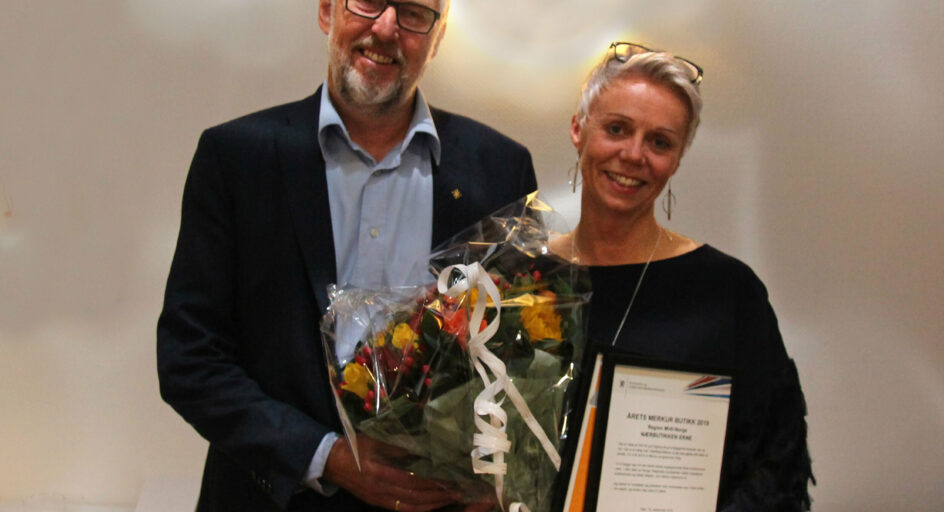 2 personar med blomst og diplom. Foto.