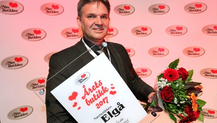 Person med diplom og blomst. Foto.
