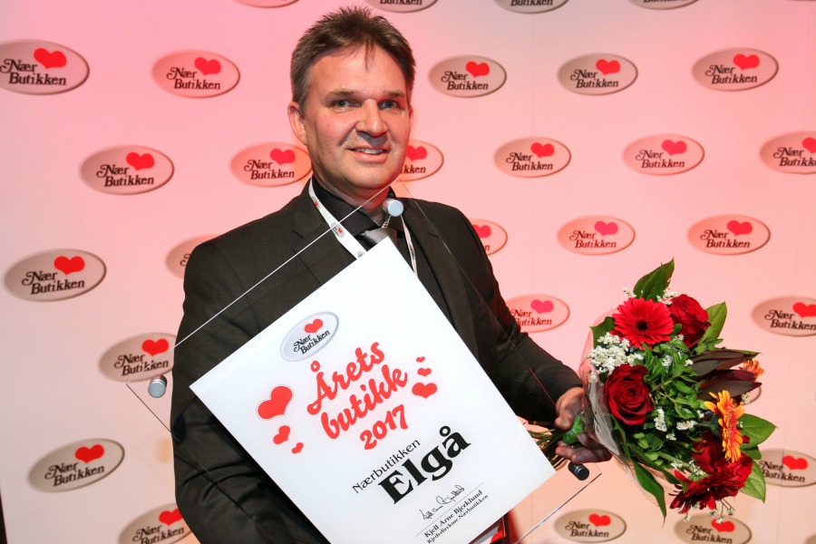 Person med diplom og blomst. Foto.