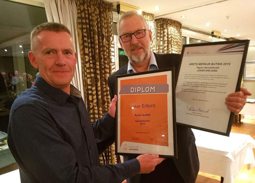 2 personar med blomst og diplom. Foto.