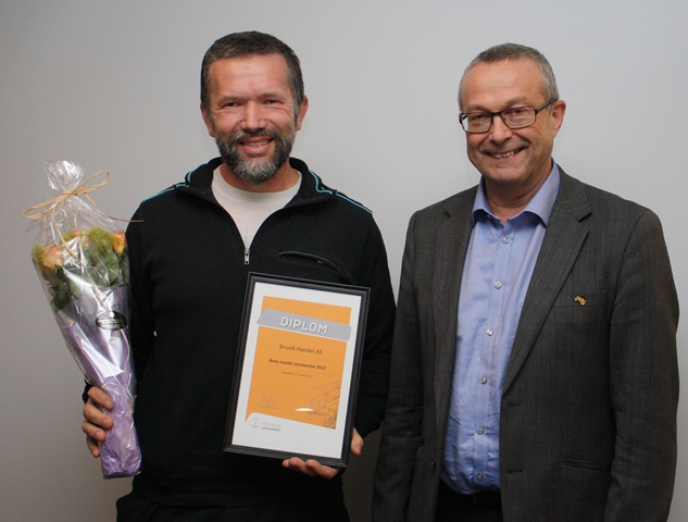 To personar med blomst og diplom