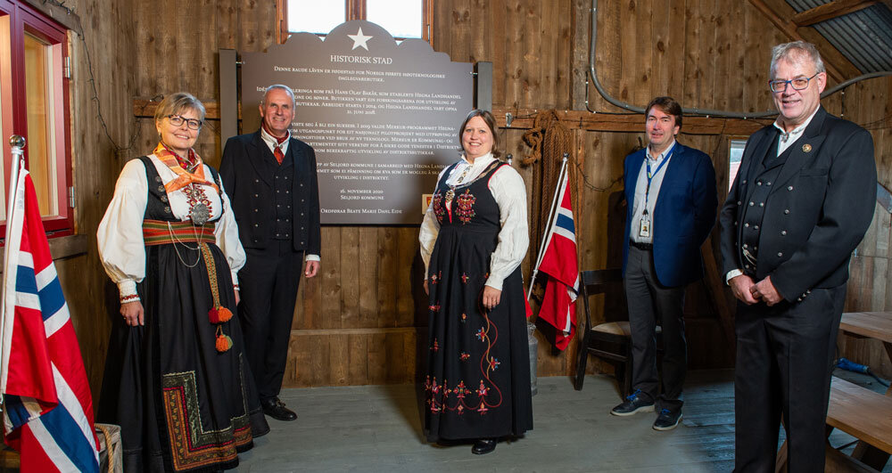5 personer i bunad med norske flagg