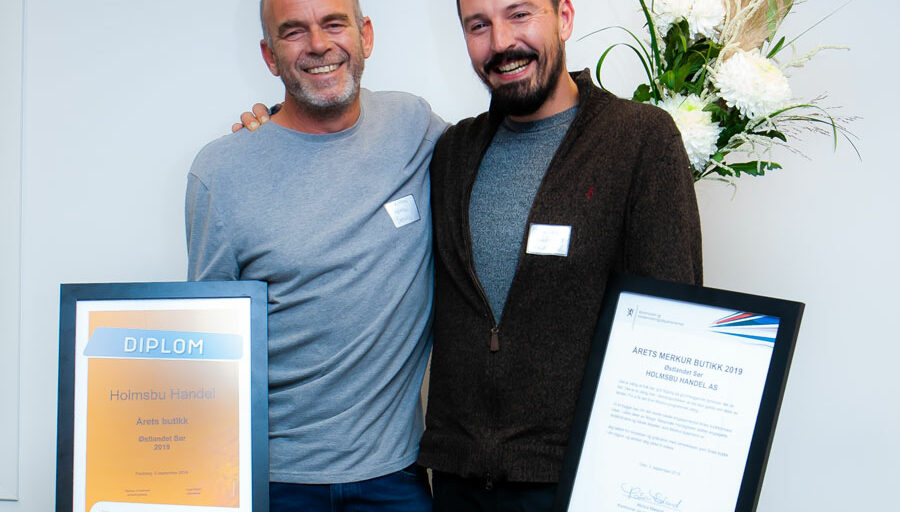 2 personar med blomst og diplom. Foto.