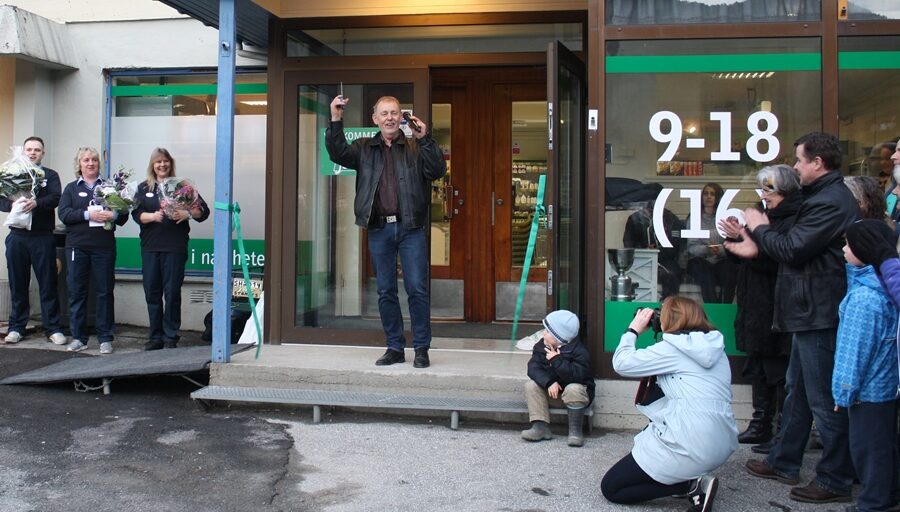 Flere personer samlet til snorklipping utafor butikk. Foto.