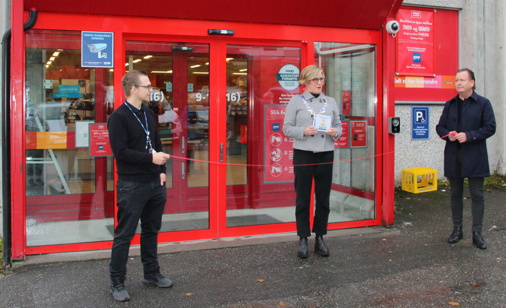 Tre personer utenfor butikk