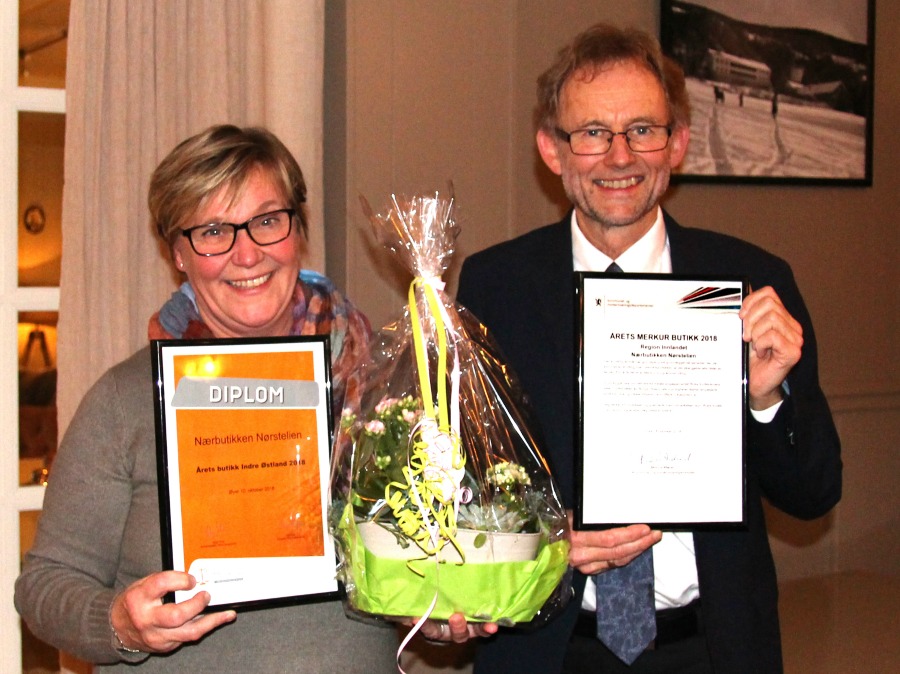 2 personar med blomst og diplom. Foto.
