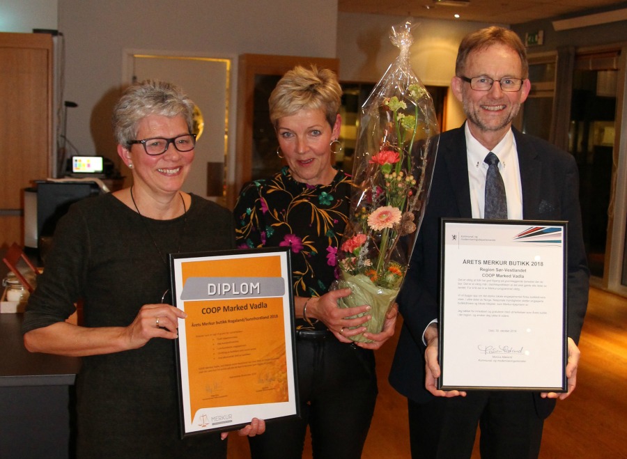 3 personar med blomst og diplom. Foto.