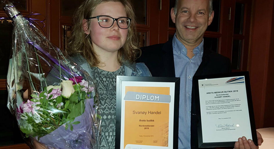 To personer med blomster og diplom. Foto.
