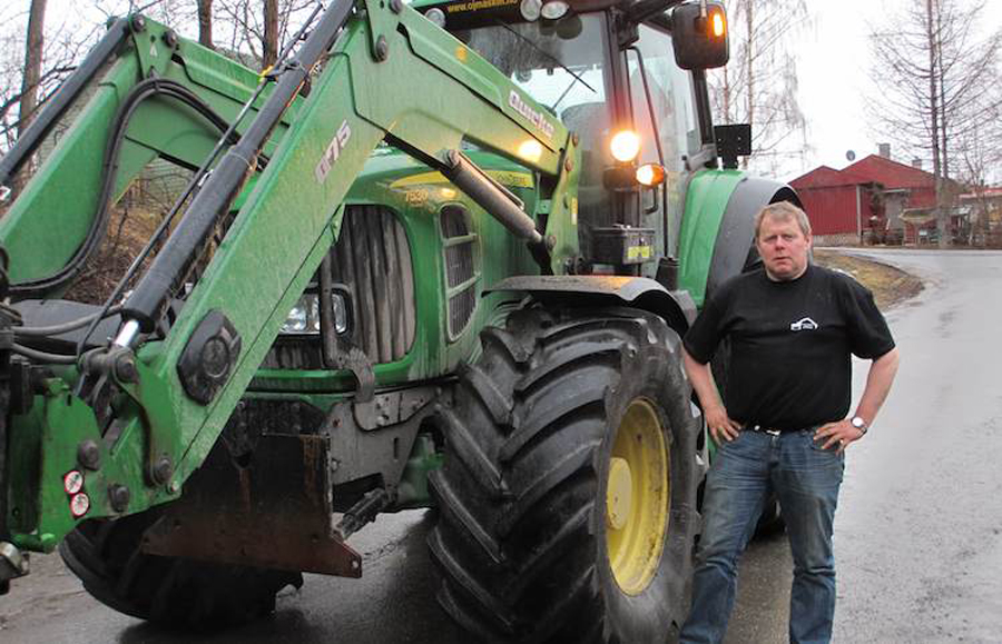 Person framfor traktor. Foto.