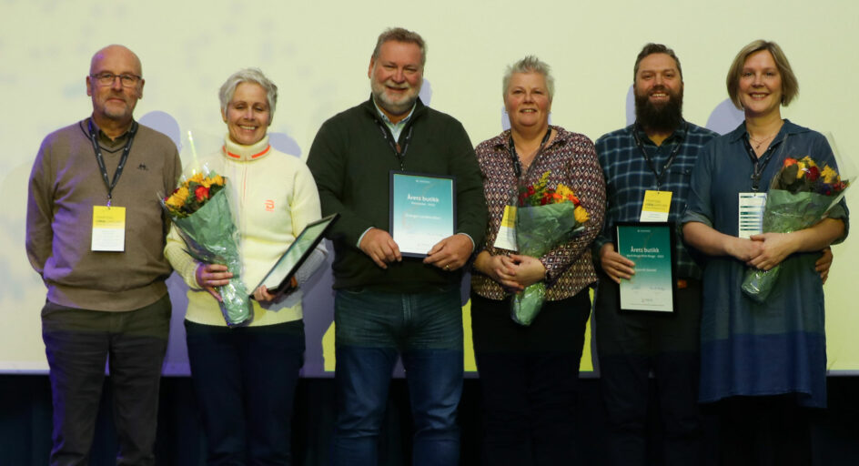 6 personer med blomster og diplomer. Foto.