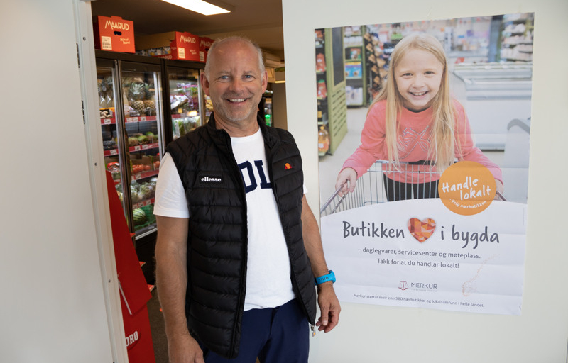 Portrett av mann ved plakat i butikk