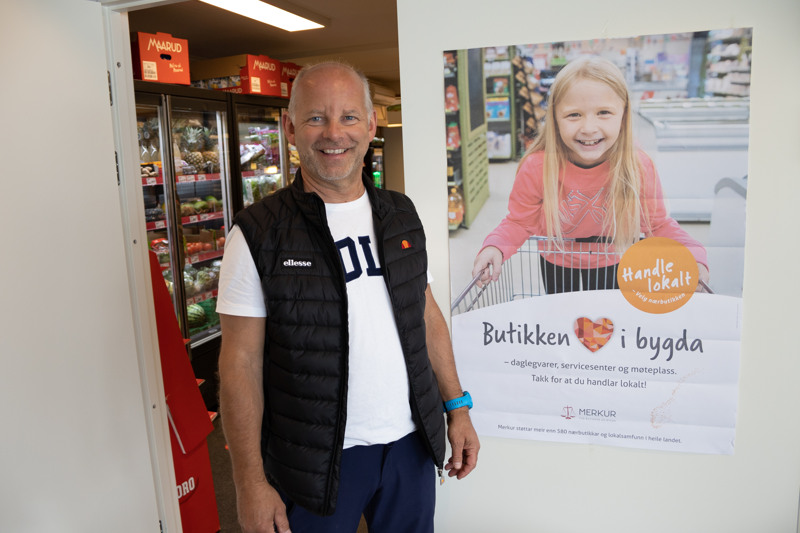 Portrett av mann ved plakat i butikk