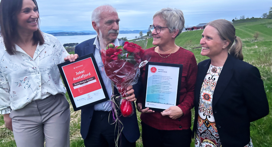 En gruppe mennesker som står ved siden av hverandre og holder blomster og diplomer