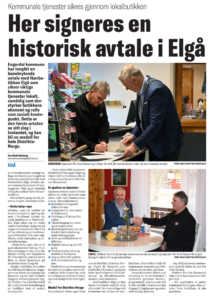 En avisartikkel med et bilde av to menn ved et bord.
