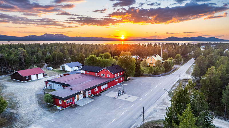 En rød bygning i en grønn skog.