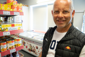 Portrett av mann ved butikkhylle